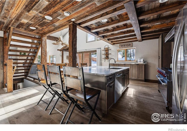 kitchen featuring appliances with stainless steel finishes, sink, wood ceiling, and a kitchen island with sink