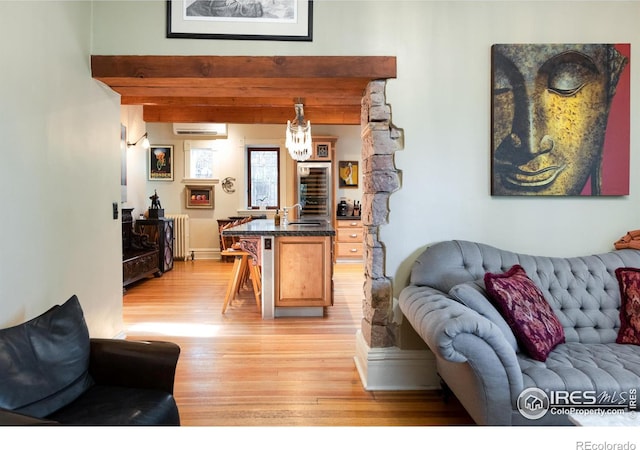 living room featuring radiator heating unit, light hardwood / wood-style flooring, beamed ceiling, and a wall unit AC