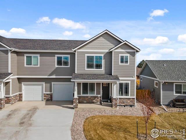 view of front of house featuring a garage, stone siding, covered porch, and driveway