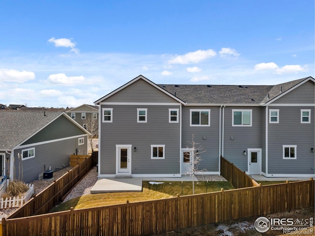 back of property with central AC, a patio area, a fenced backyard, and a residential view