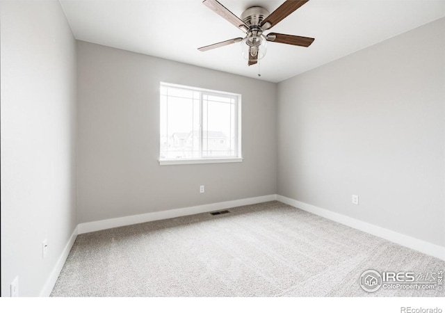 carpeted empty room with ceiling fan, visible vents, and baseboards