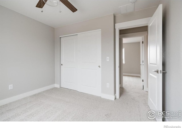 unfurnished bedroom with a ceiling fan, baseboards, a closet, and light colored carpet