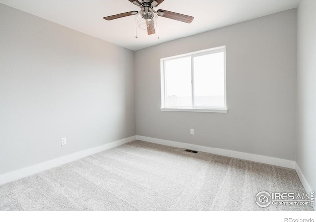 spare room with a ceiling fan, carpet, visible vents, and baseboards