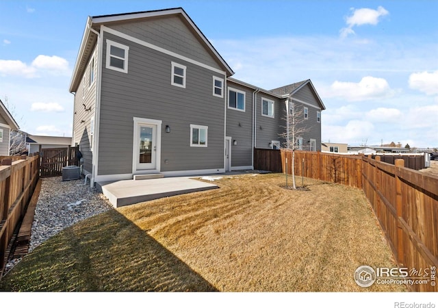 back of house featuring a patio, a yard, and a fenced backyard