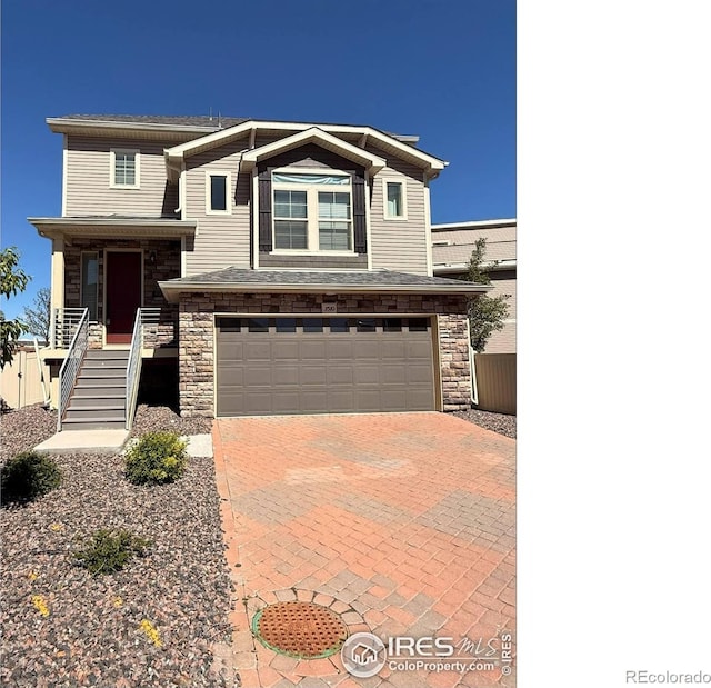 3510 Valleywood Ct, Johnstown, CO 80534 - view of front of home featuring an attached garage, stairs, stone siding, and decorative driveway