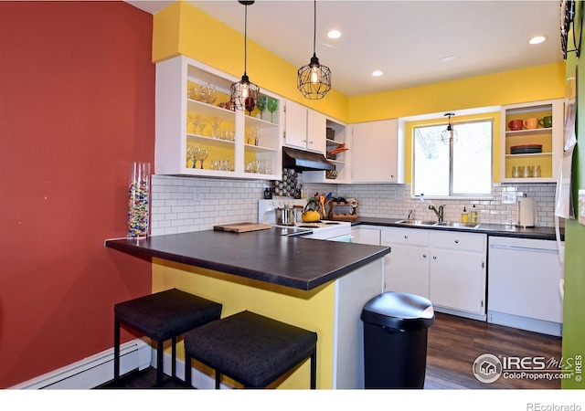 kitchen featuring white appliances, a breakfast bar, white cabinetry, kitchen peninsula, and baseboard heating