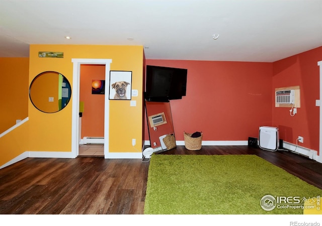 unfurnished living room with baseboard heating, dark hardwood / wood-style flooring, and a wall mounted AC