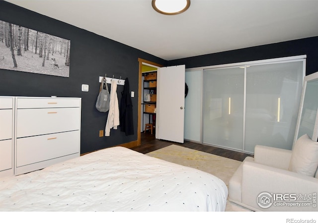 bedroom with a closet and hardwood / wood-style floors