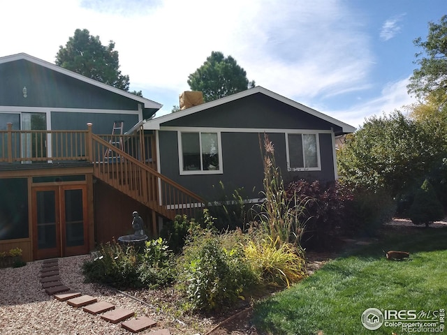 rear view of house with stairway, french doors, and a wooden deck