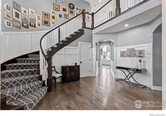 stairway featuring a high ceiling and wood-type flooring