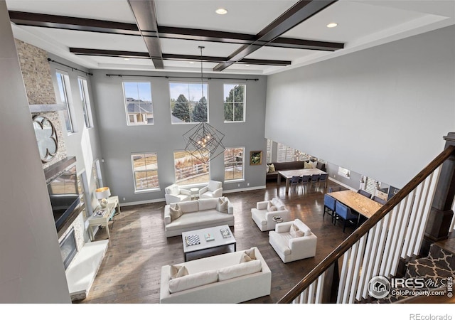 living room with dark hardwood / wood-style flooring, plenty of natural light, beam ceiling, and coffered ceiling