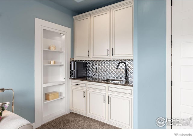 kitchen with sink, carpet floors, built in shelves, and backsplash