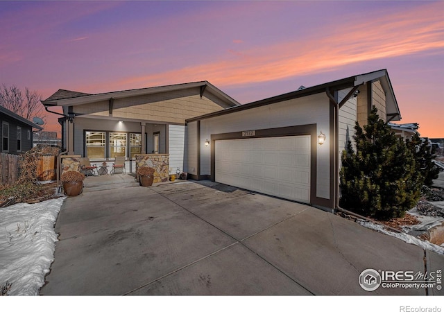 view of front of property with a garage, fence, and concrete driveway