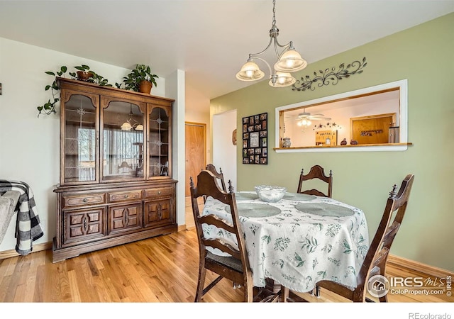 dining room with light hardwood / wood-style flooring and a notable chandelier