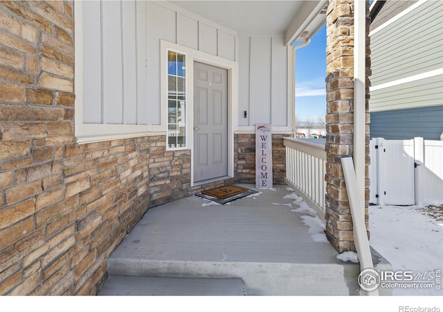 entrance to property with stone siding and board and batten siding