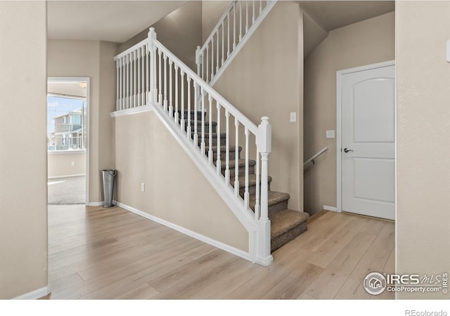 staircase with baseboards and wood finished floors