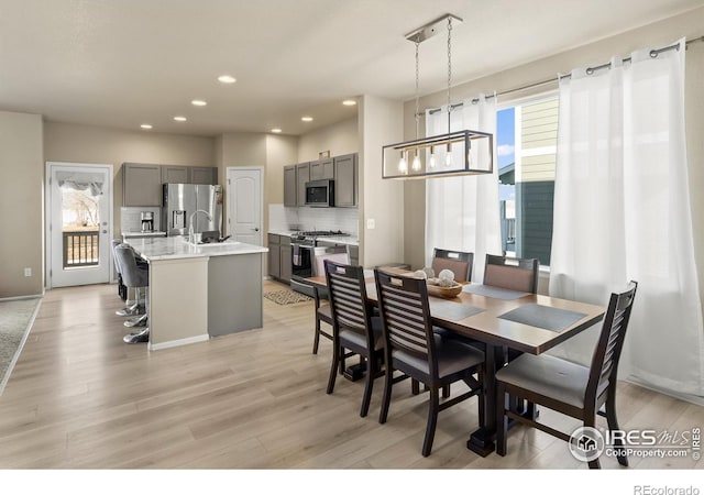 dining room featuring recessed lighting, a healthy amount of sunlight, and light wood finished floors