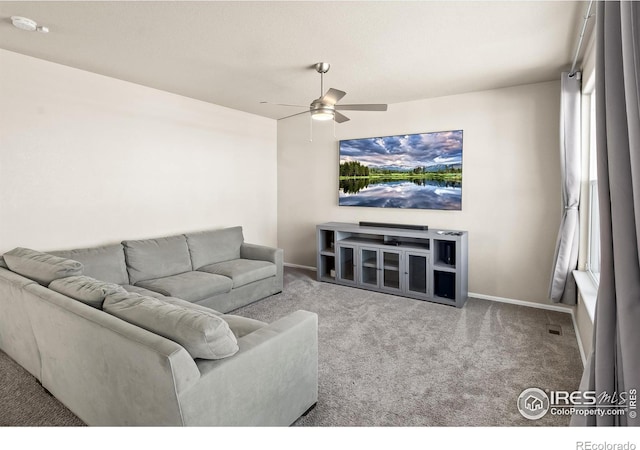 carpeted living room featuring ceiling fan and baseboards