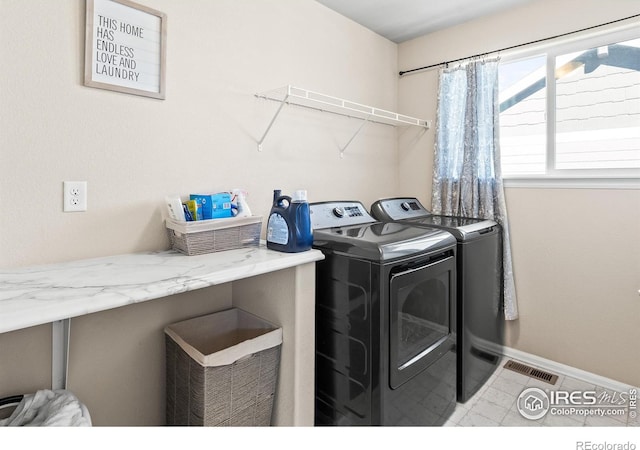 laundry room with visible vents, washing machine and dryer, tile patterned flooring, laundry area, and baseboards