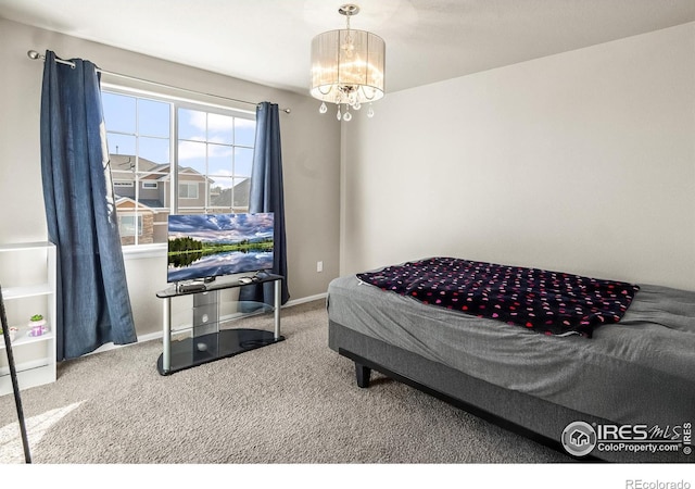 bedroom with carpet, a chandelier, and baseboards