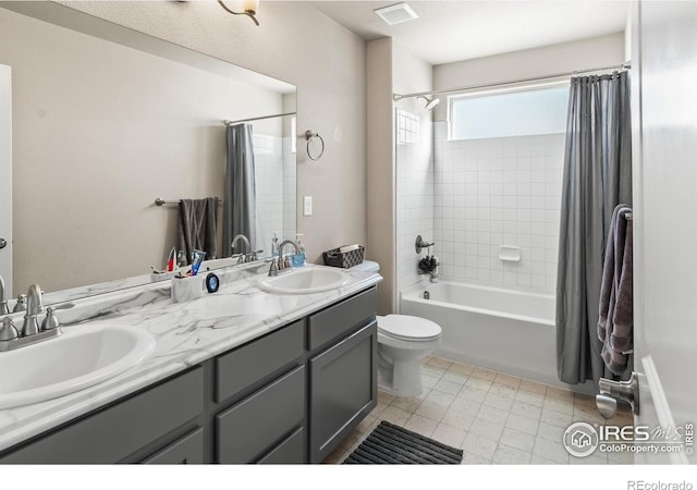 bathroom featuring double vanity, visible vents, shower / bath combo with shower curtain, and a sink