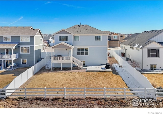 back of house with a fenced backyard and a residential view