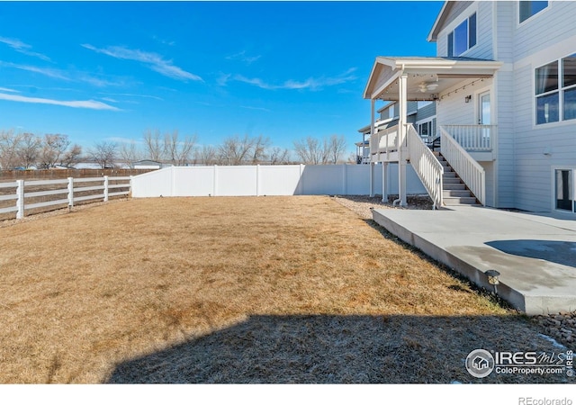 view of yard featuring a patio area, a fenced backyard, and stairway