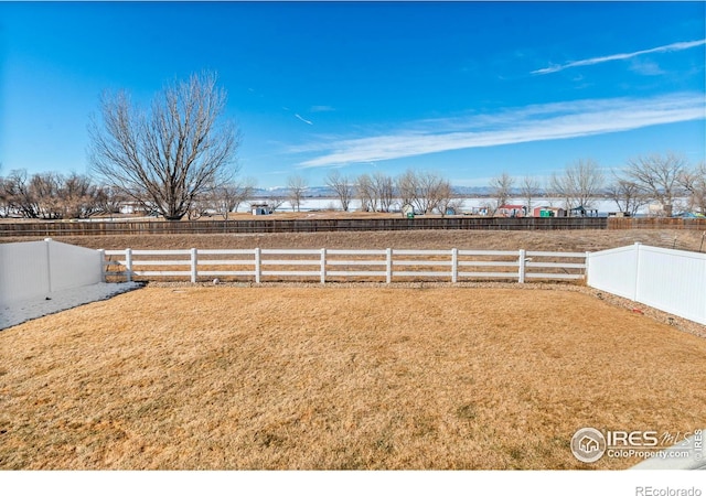 view of yard featuring a rural view and fence