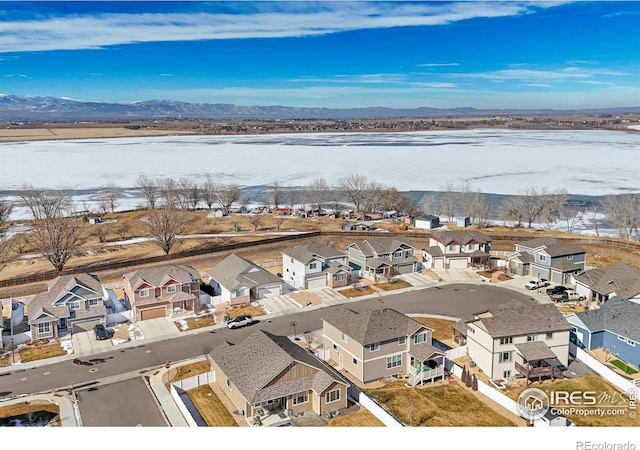 snowy aerial view with a residential view and a mountain view