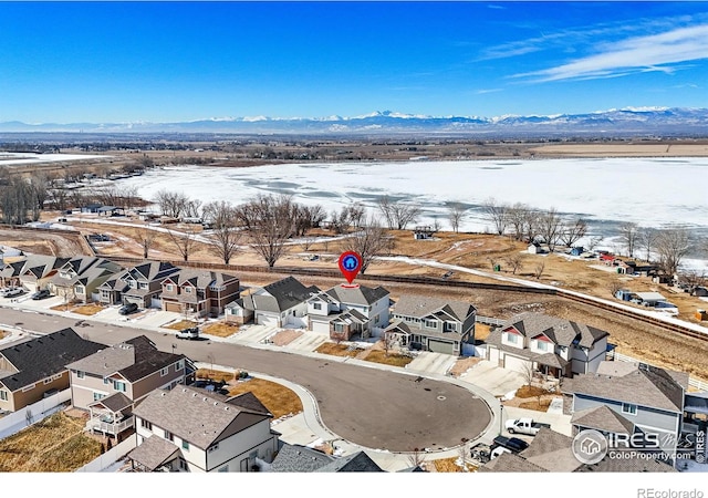 snowy aerial view with a residential view and a mountain view