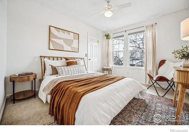 bedroom featuring carpet floors, baseboards, a ceiling fan, and a textured ceiling