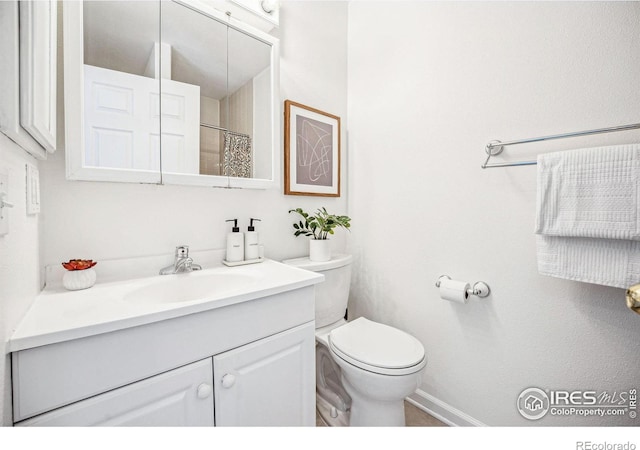 bathroom featuring toilet, curtained shower, and vanity