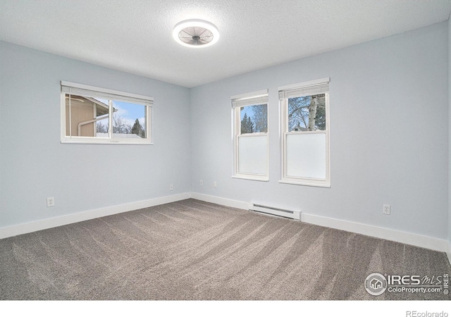 carpeted spare room featuring a baseboard heating unit, baseboards, and a textured ceiling