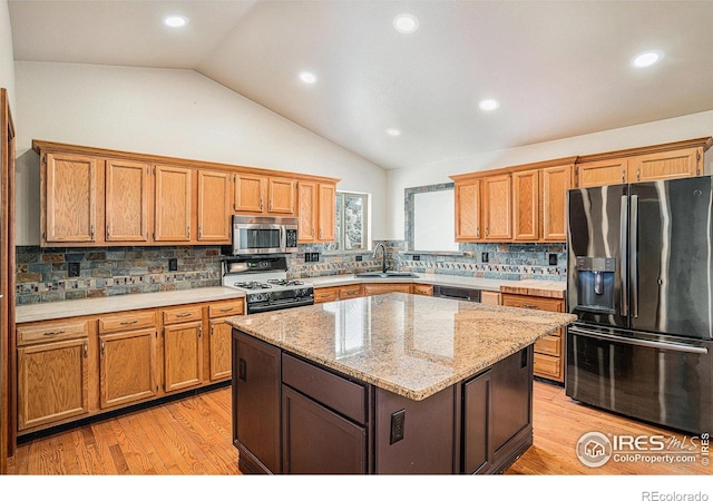kitchen featuring stainless steel microwave, brown cabinets, fridge with ice dispenser, white gas stove, and a sink