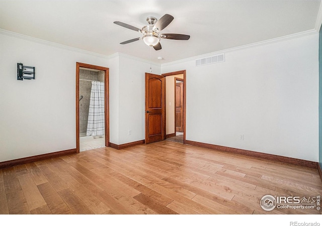 unfurnished room with light wood-type flooring, baseboards, visible vents, and ornamental molding