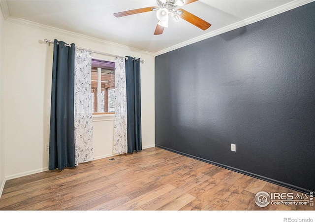unfurnished room featuring crown molding, a ceiling fan, wood finished floors, and baseboards
