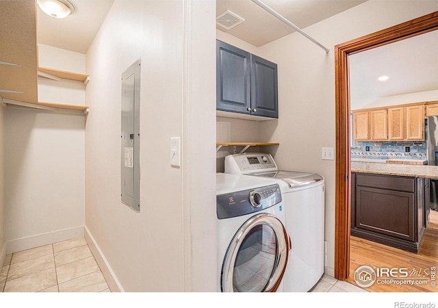 laundry room with washing machine and clothes dryer, cabinet space, visible vents, and light tile patterned flooring