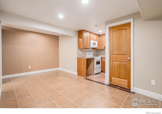 kitchen featuring baseboards, light countertops, recessed lighting, and white appliances