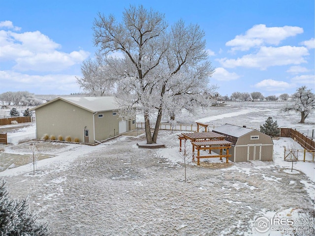 yard covered in snow featuring fence and an outdoor structure