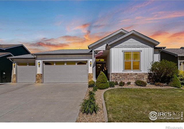 view of front facade featuring driveway, a garage, stone siding, and board and batten siding