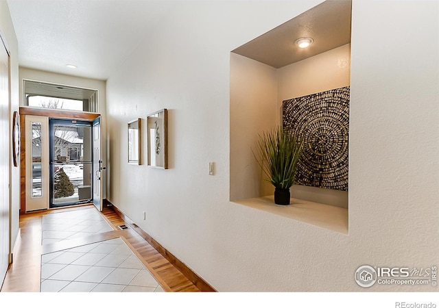entryway with baseboards, tile patterned floors, and visible vents