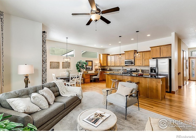 living area featuring ceiling fan, recessed lighting, and light wood-style floors