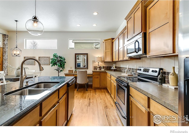 kitchen featuring light wood-style flooring, a sink, stainless steel appliances, pendant lighting, and recessed lighting