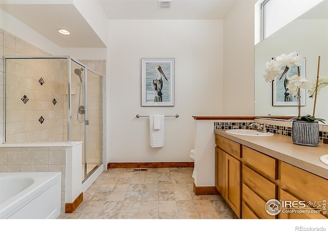 full bath featuring toilet, baseboards, a stall shower, and a sink