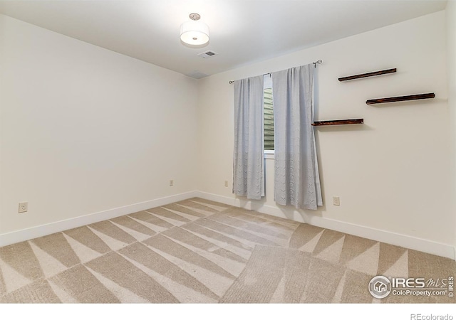 carpeted spare room with visible vents and baseboards