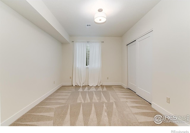 unfurnished room with baseboards, visible vents, and carpet