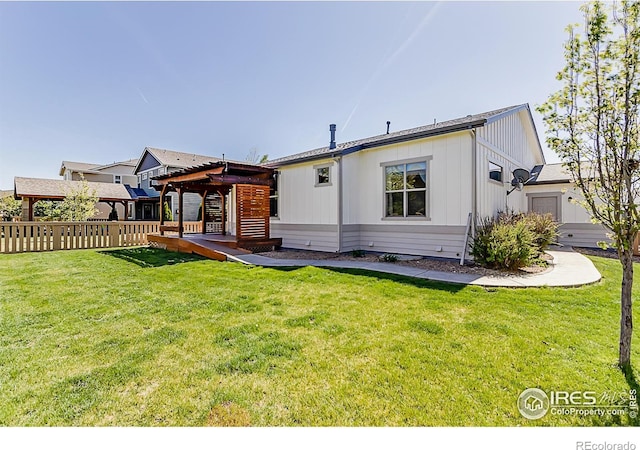 back of house with a yard, a wooden deck, a pergola, and fence