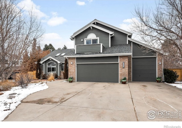 view of front facade with a garage, brick siding, driveway, and a shingled roof