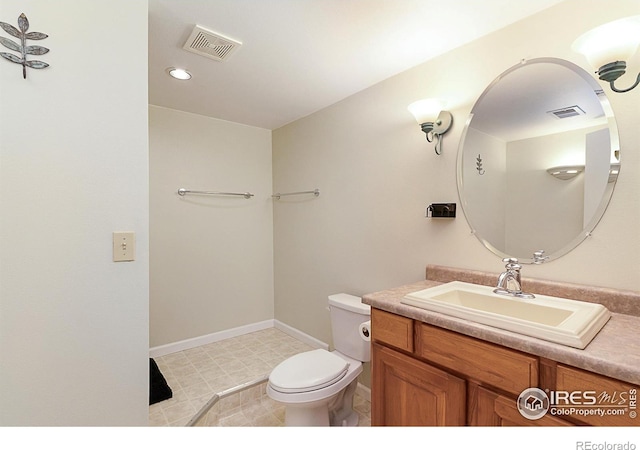 bathroom featuring toilet, vanity, visible vents, and baseboards