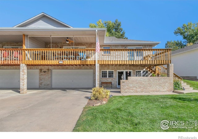 back of property featuring brick siding, stairway, ceiling fan, a garage, and driveway